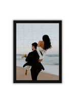wooden personalized puzzle featuring a romantic couple walking by the ocean at sunset framed in black